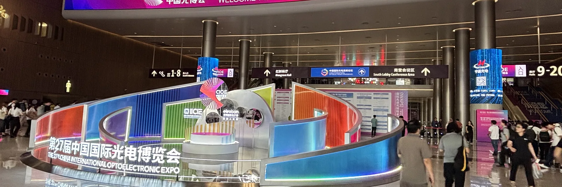 Photograph of the CIOE 2026 main lobby showing the 27th exhibition welcome display and attendee flow at the Shenzhen convention center